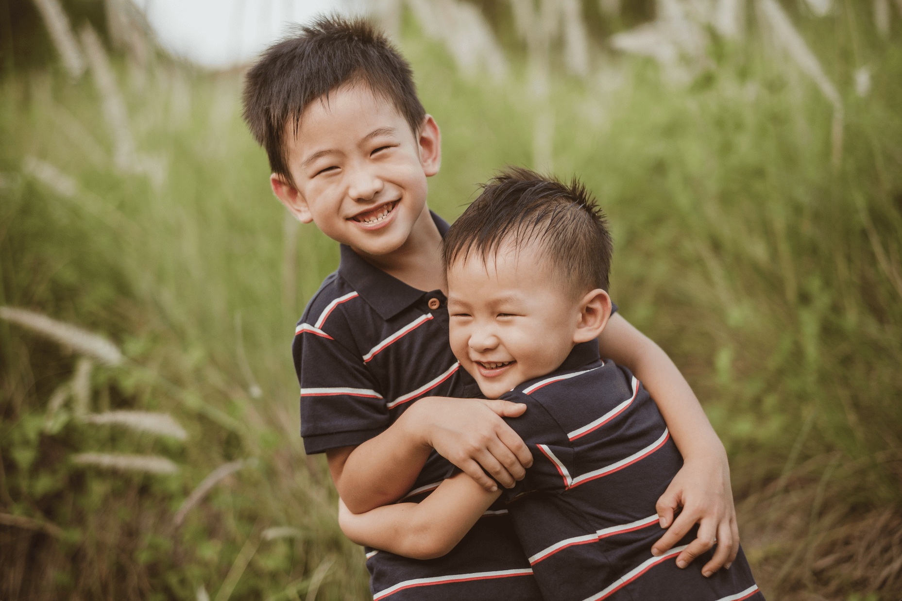 brothers smiling and hugging each other